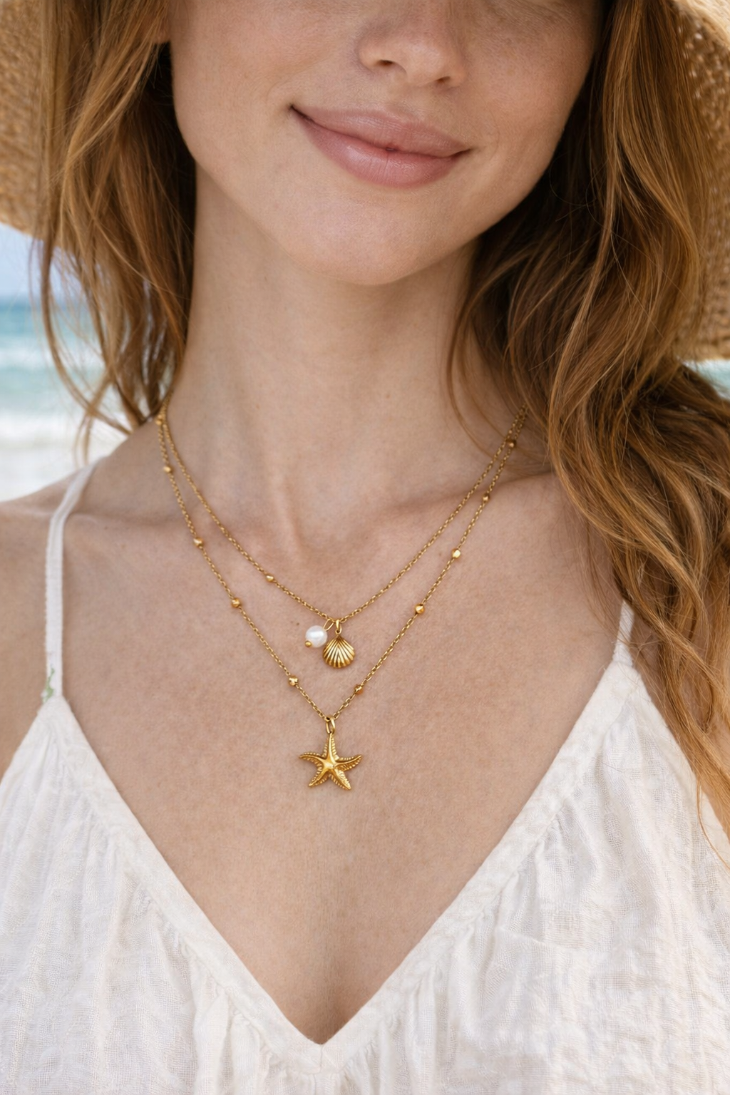 Woman wearing a gold necklace with star pendant on a beach