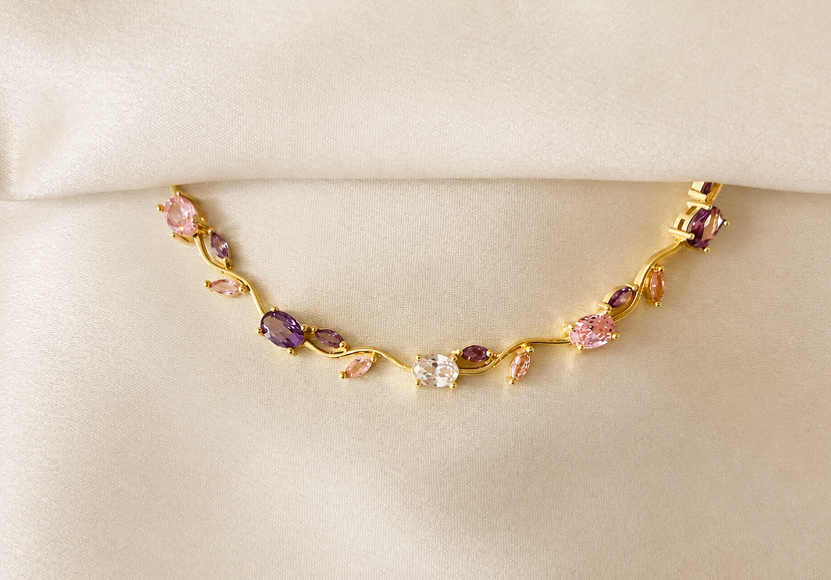 Gold bracelet with multicolored gemstones on a beige background