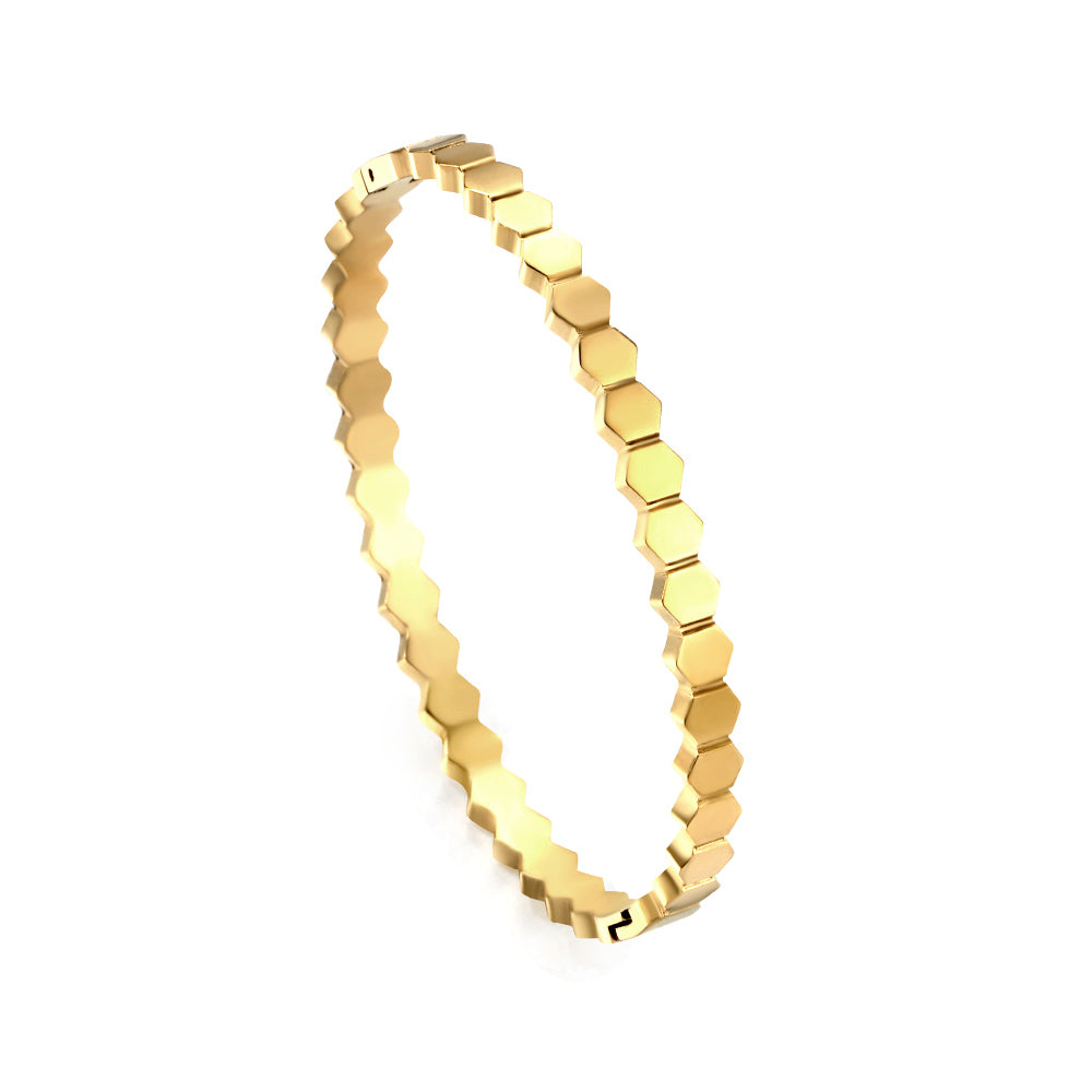 Gold bracelet with hexagonal pattern on a white background