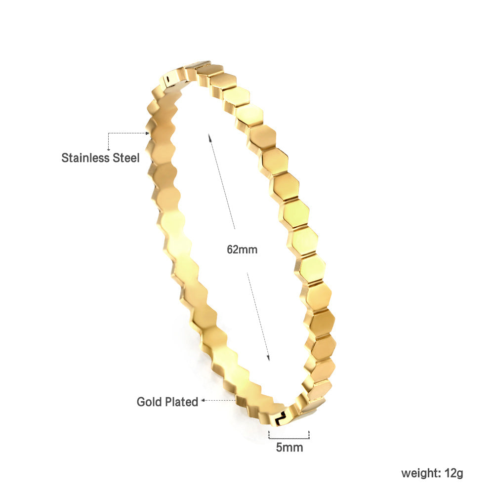 Gold bracelet with hexagonal pattern on a white background