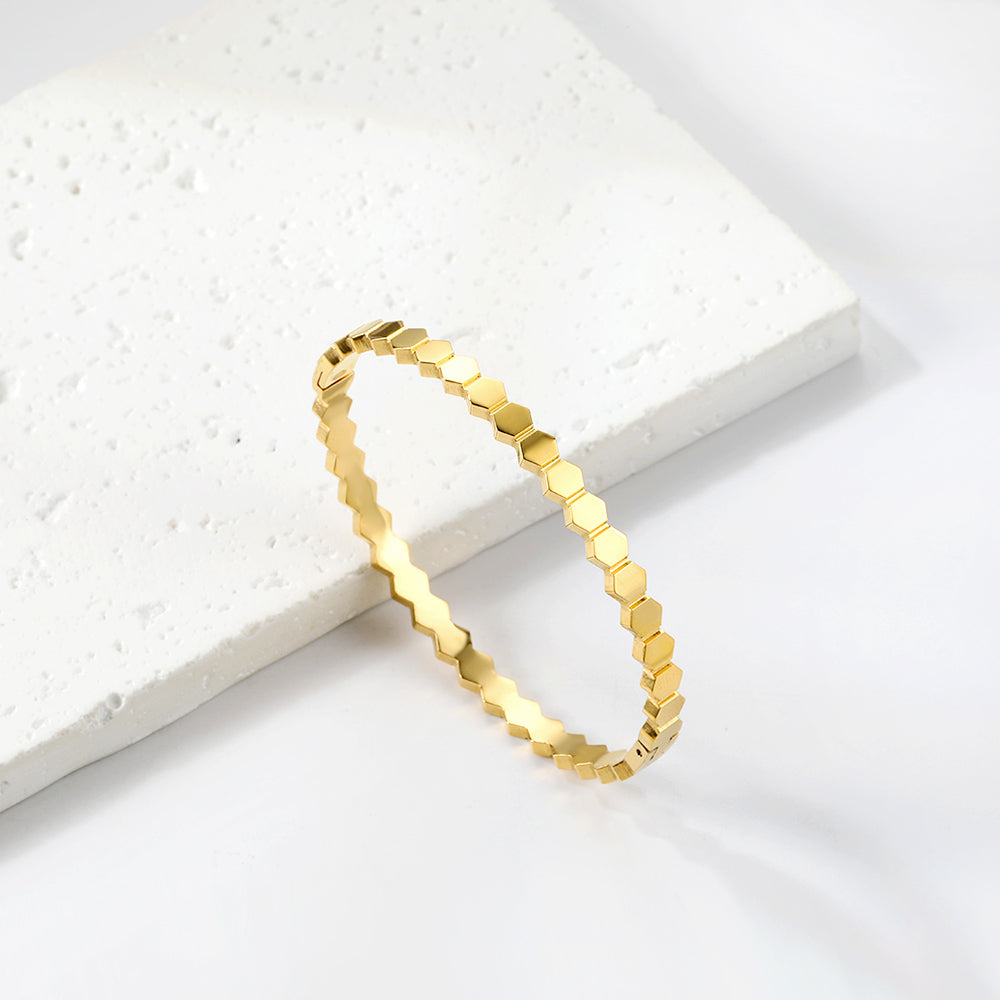 Gold bracelet on a white stone surface