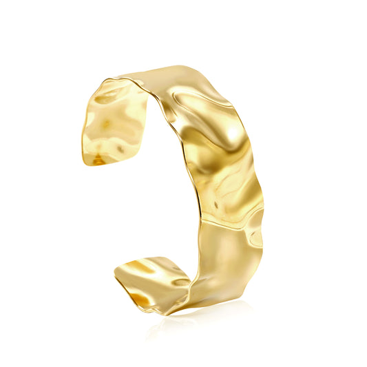 Gold ring with a wavy design on a white background