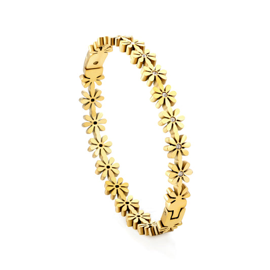 Gold bracelet with floral designs on a white background