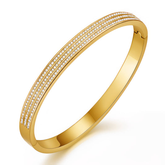 Gold bracelet with embedded diamonds on a white background