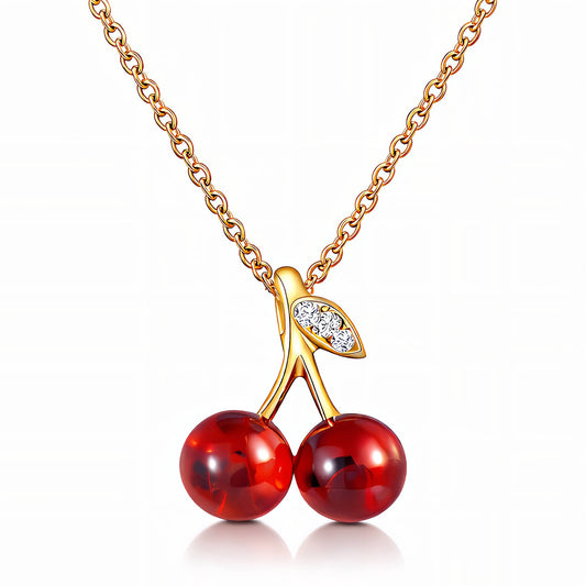Gold necklace with a cherry pendant on a white background