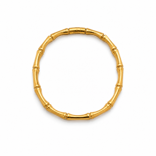Gold bracelet with bamboo design on a white background