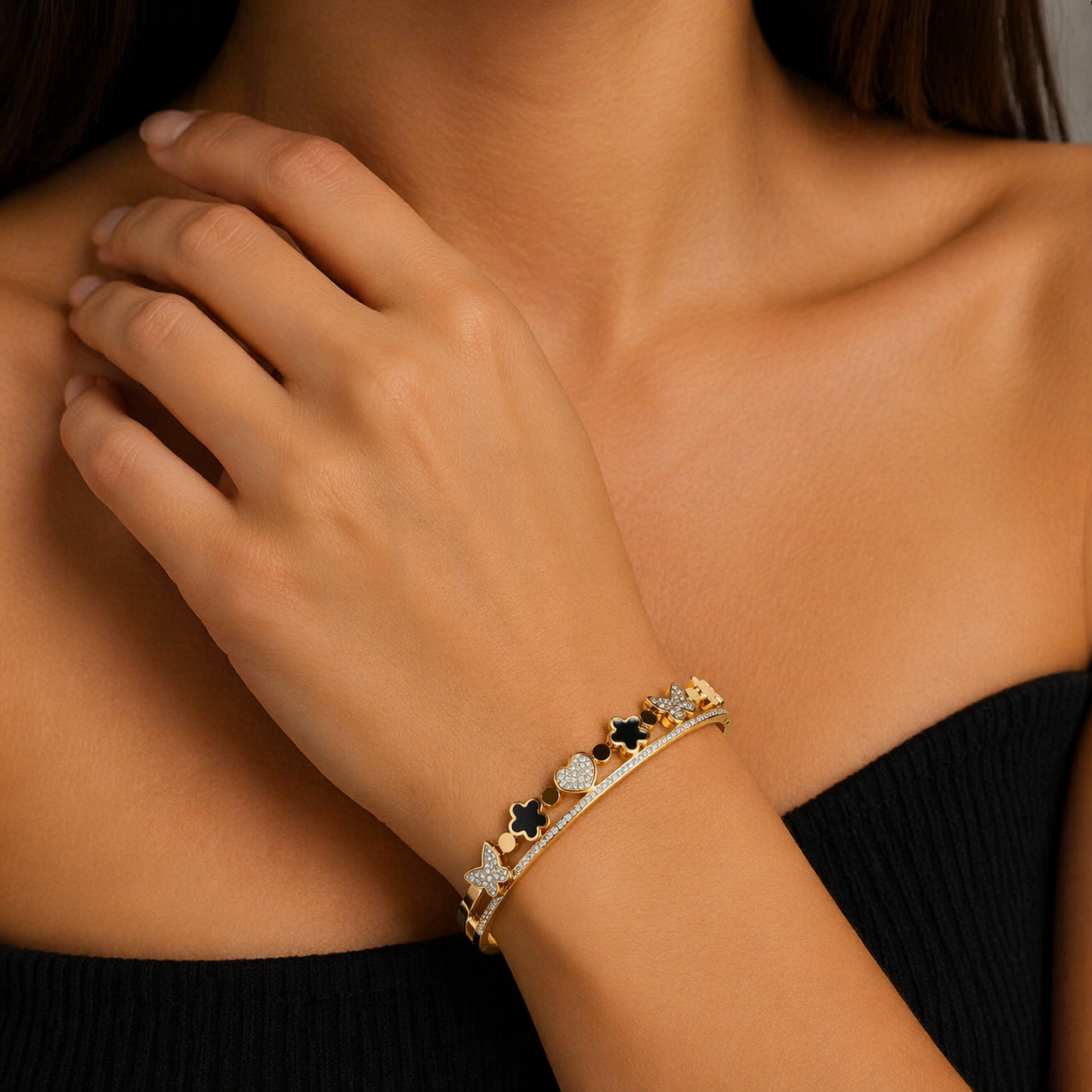 Gold bracelet with black and white stones on a person's wrist