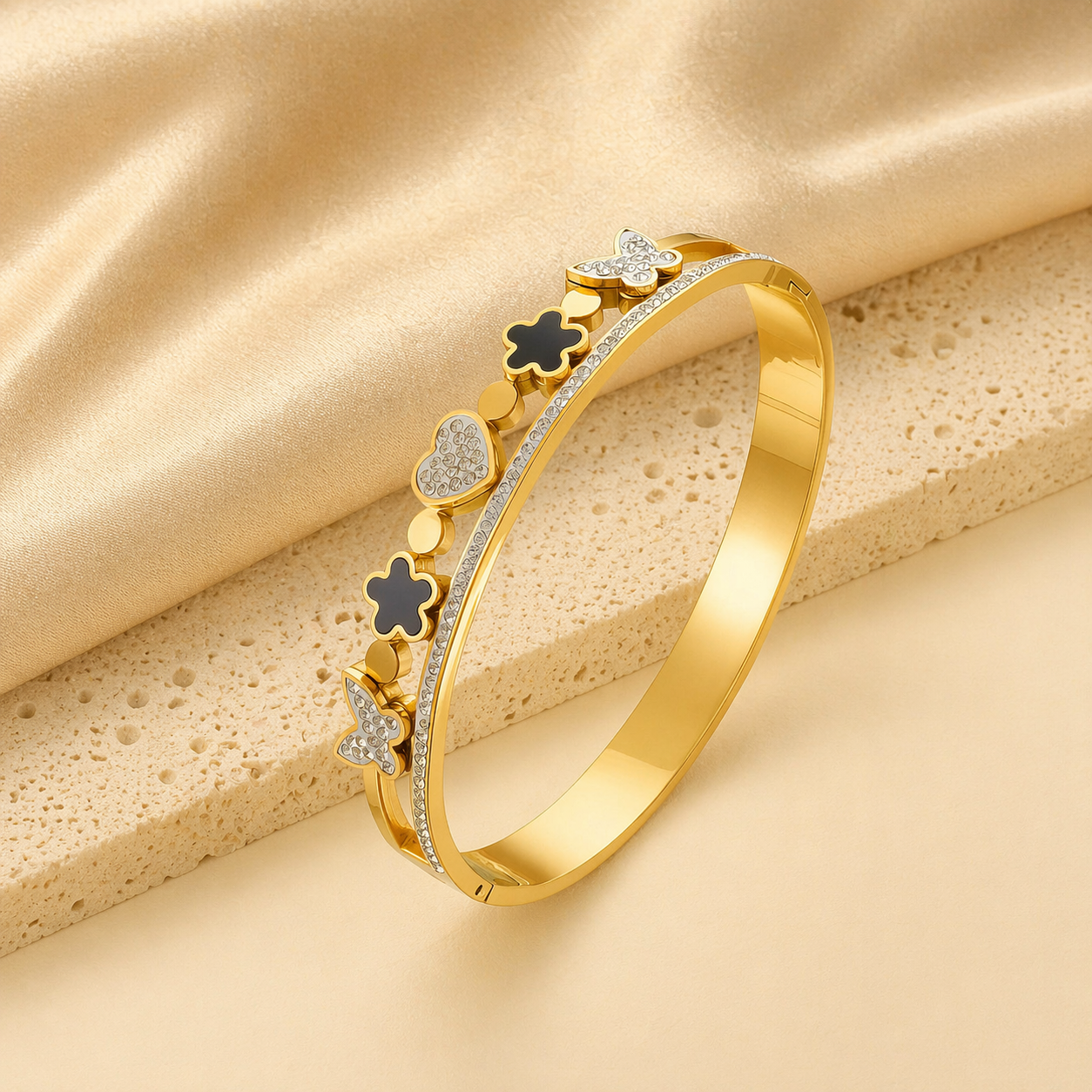 Gold bracelet with decorative elements on a beige fabric background