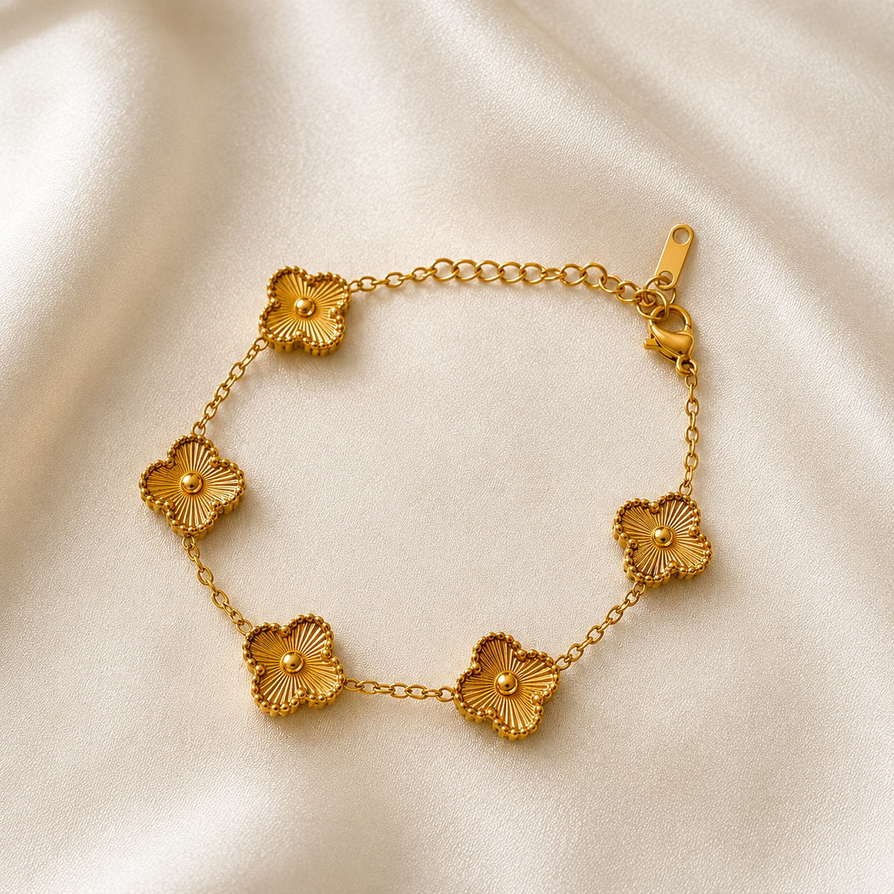 Gold bracelet with floral designs on a beige fabric background