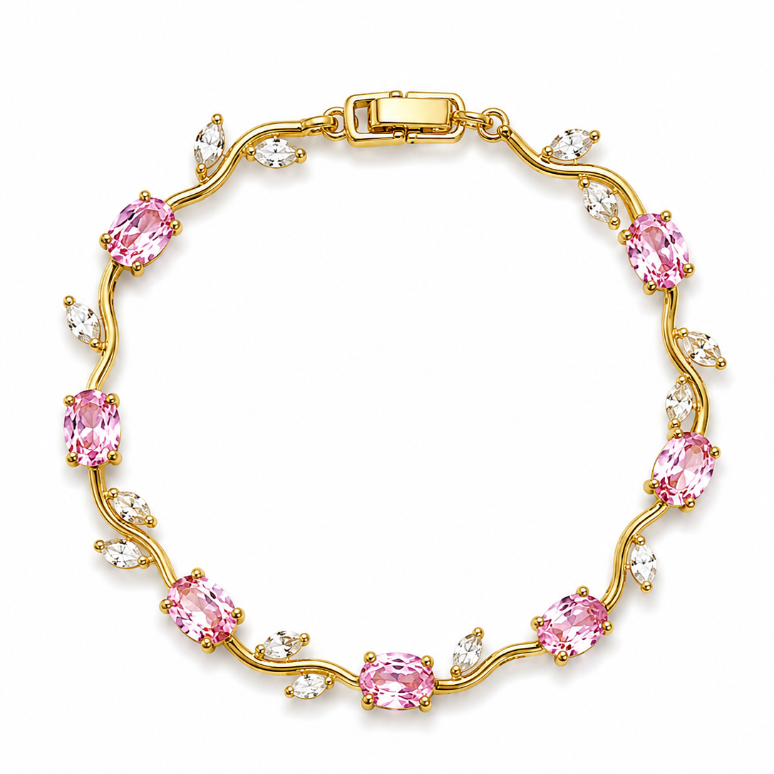 Gold bracelet with pink and clear gemstones on a white background