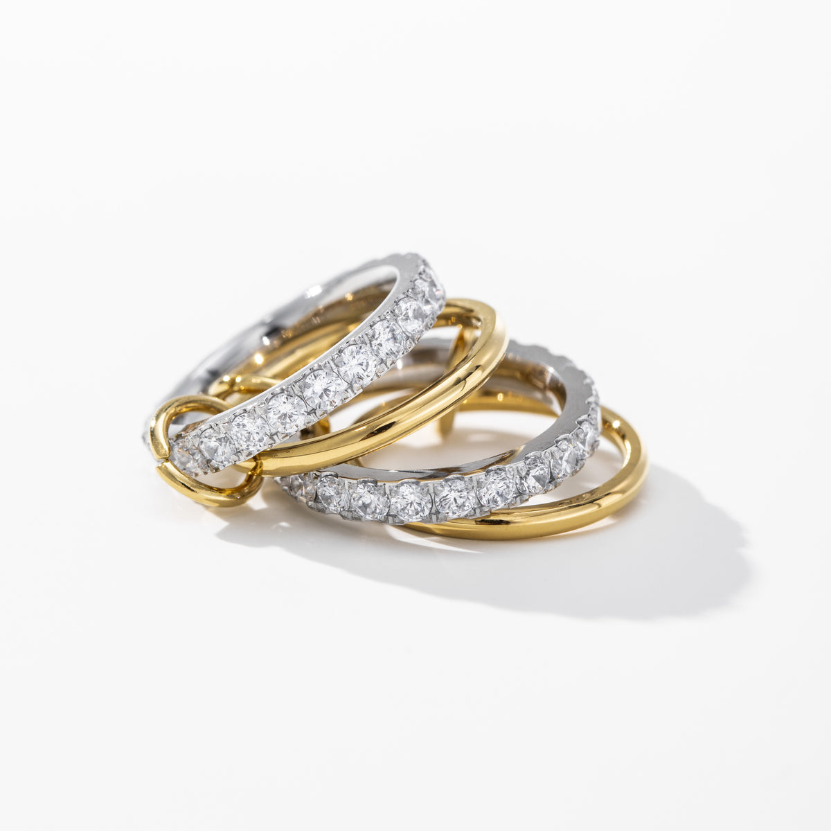 Three diamond-studded rings stacked on a white background