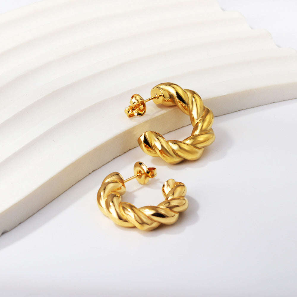 Gold hoop earrings on a white surface