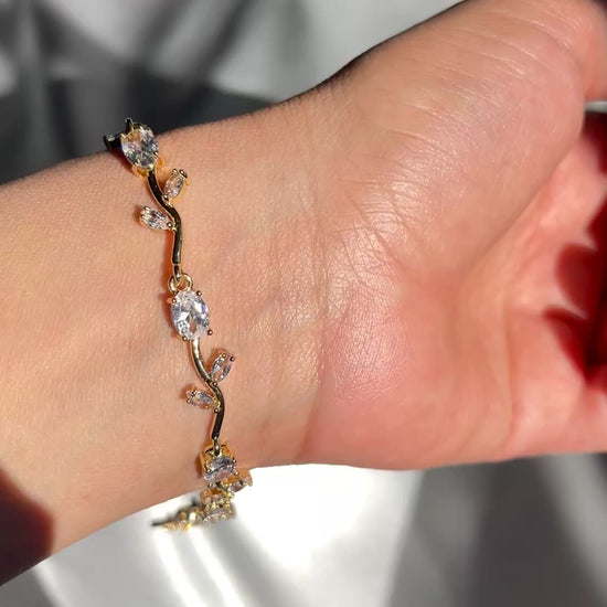Hand wearing a delicate bracelet with a soft background