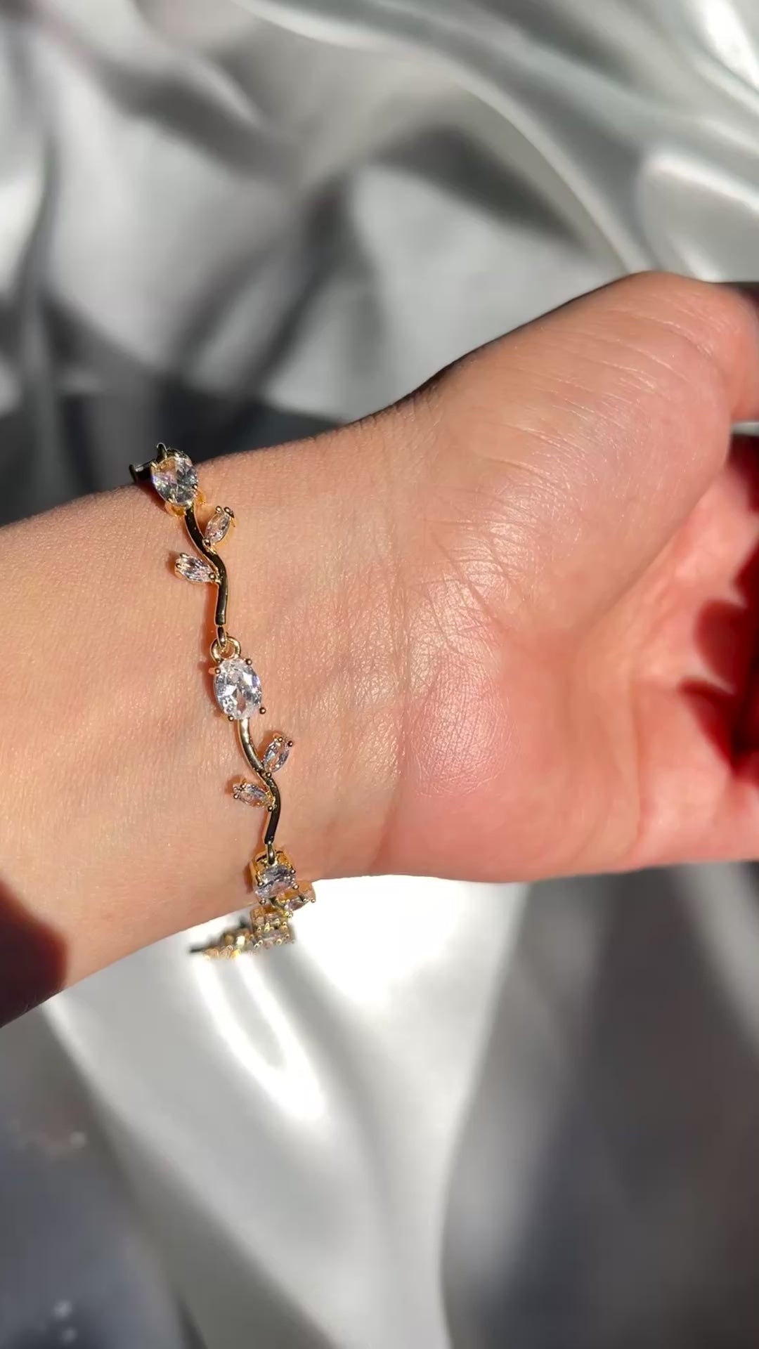 Hand wearing a delicate bracelet with a soft background